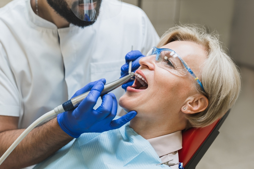 Dentist performing a dental procedure on a patient using dental instruments during a root canal treatment appointment.